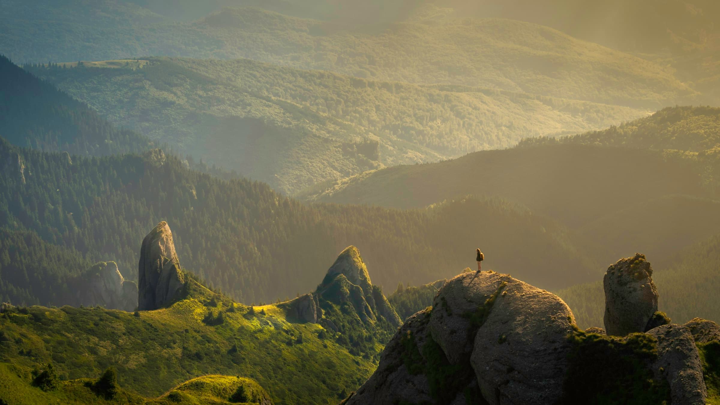 A traveller watching sunrise break over a mountain range